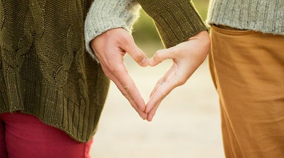 Two people making a heart with their hands