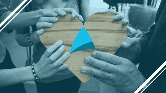 TechArk team holding a wooden heart with the company logo