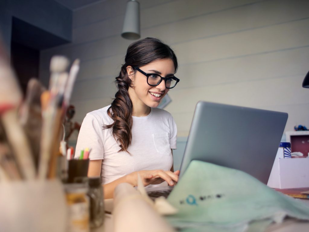 Woman wearing glasses typing on laptop