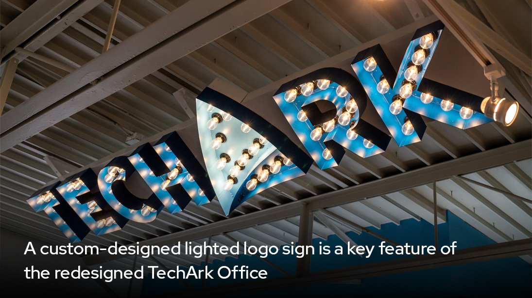 A custom-designed light logo sign is a key feature of the redesign of Techark Office-alt