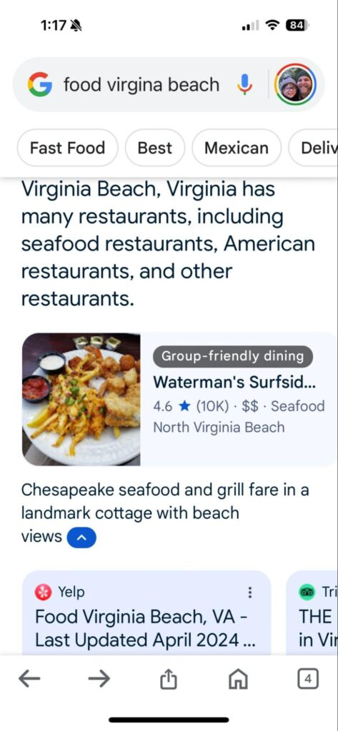 An AI-powered search for "food virginia beach." The top result is "Waterman's Surfside," showing a seafood dish in a thumbnail image next to a link to its Google Business Profile. The restaurant has an average 4.6 stars on Google with more than 10,000 ratings.