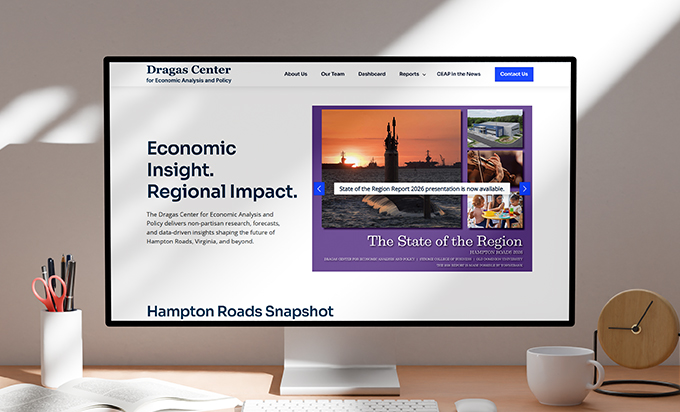 A computer monitor on a desk displays the website for the Dragas Center for Economic Analysis and Policy.